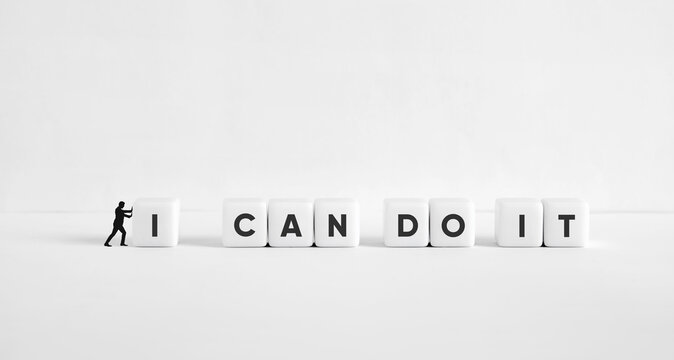 Businessman pushing letter blocks forming I CAN DO IT