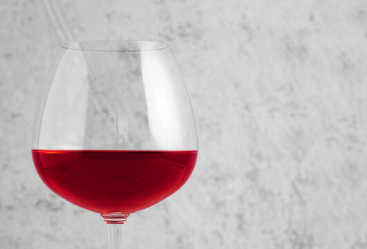 Red wine in glass on gray stone background