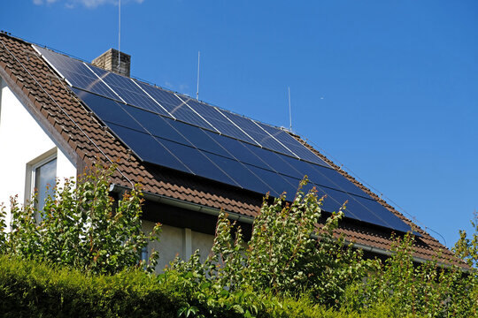 Home solar panel. Alternative energy is used for heating and water heating. Eco-friendly alternative energy for house. Residential family house suburban. Brown tile roof of home with solar panels.