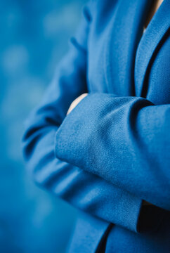 Person with arms crossed wearing a blue blazer