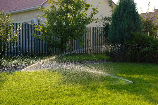 Automatic garden irrigation system watering lawn. Savings of water from sprinkler irrigation system with adjustable head. Automatic equipment for irrigation and maintenance of lawns, gardening.