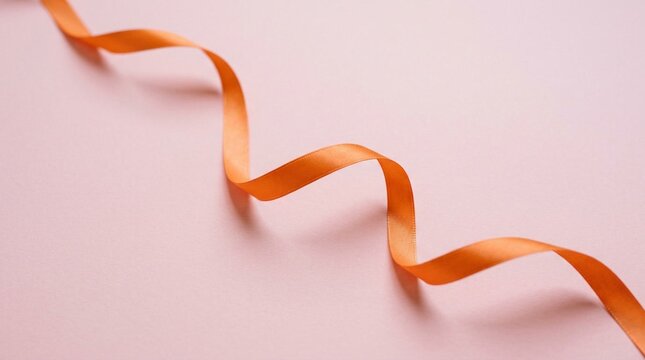 Single orange satin ribbon curling loosely across a soft pale pink surface, gentle shadow, elegant minimalist composition, luxurious fabric texture, delicate flowing strip, romantic pastel
