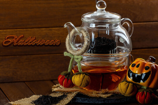 Teiera con t&egrave; nero e simboli di Halloween