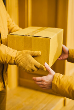 Delivery person handing a cardboard box to a customer