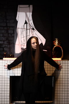 Dark cloak individual enacting ritual with glowing surroundings at dusk