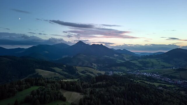 Aerial Forward Hyperlapse of Mountain Peak with Crescent Moon at Dusk Sky