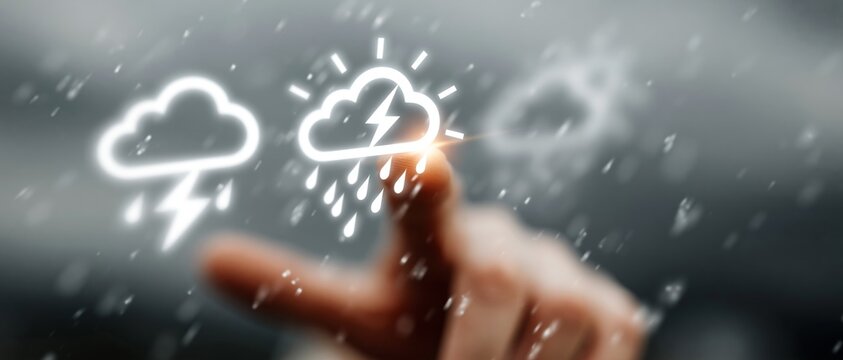 A hand interacts with glowing digital weather icons showing rain and lightning against a blurred background.