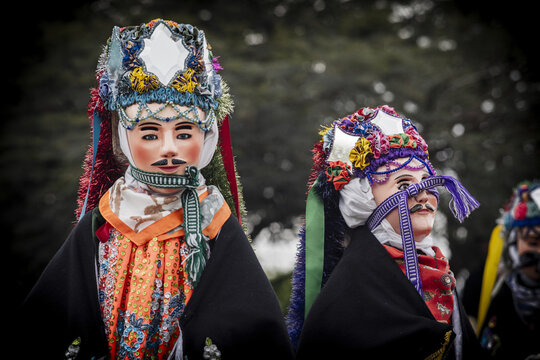 View of traditional dancers wearing ornate masks and colorful costumes during a cultural celebration in MICHOACAN, Mexico.