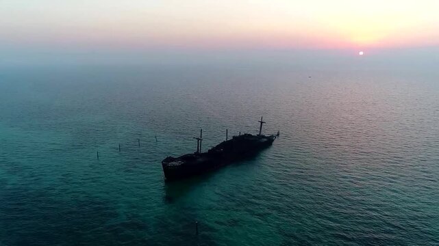 Calm aerial footage of open sea around Kish Island with distant ship under soft sunset light.