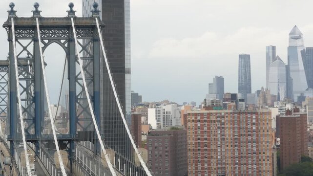 Manhattan bridge from above, rooftop in Brooklyn Dumbo, New York, United States. City traffic on transport bridge aerial view, cars on road. Hudson Yards district skyscrapers, towers on rainy day.
