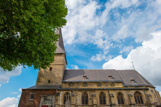 Trees and an old church in sunlight and shadow in green woodland in summer, Voeren, Limburg, Belgium, August, 2026