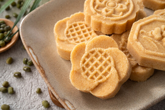 Traditional Chinese peanut mung bean cake with floral patterns on a ceramic plate.