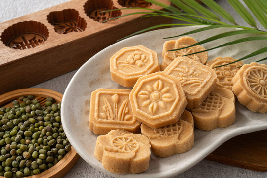 Traditional Chinese peanut mung bean cake with floral patterns on a ceramic plate.