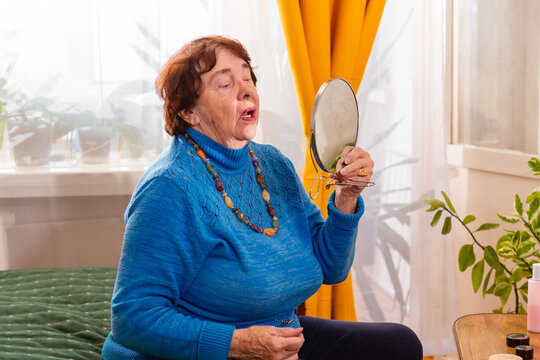 Portrait of senior Caucasian woman caring for her appearance with cosmetics at home. A regular beauty routine highlights personal wellbeing, confidence, independence