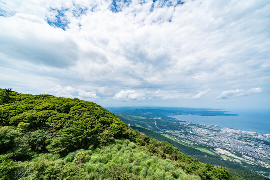 Panoramic aerial view of Beppu city and Beppu bay under blue sky with clouds from mountain viewpoint in Oita Japan