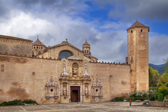 Main facade of the historic Poblet Monastery in Catalonia, Spain. Partly cloudy sky, Cistercian gothic architecture