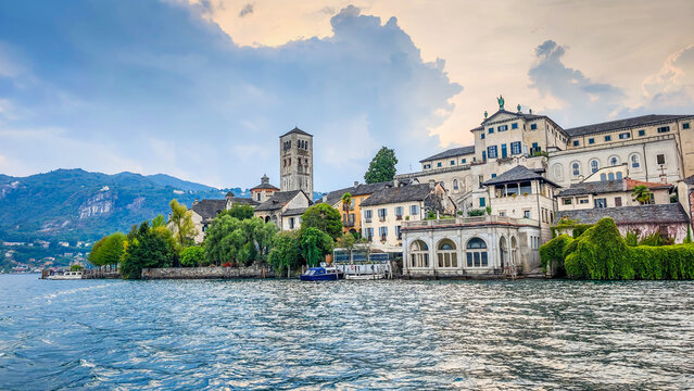 San Giulio Island on Lake Orta, Piedmont, Italy. Aerial panoramic view featuring the historic basilica and picturesque lakeside scenery surrounded by Alpine landscapes