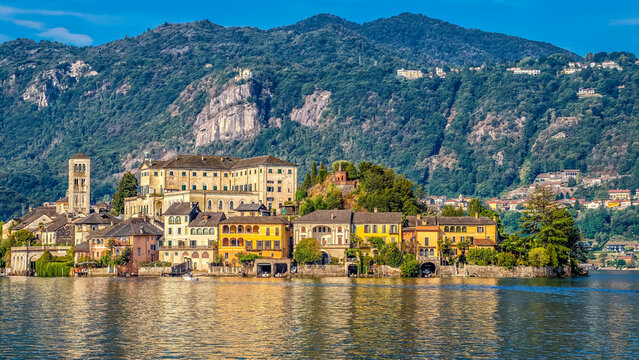 San Giulio Island on Lake Orta, Piedmont, Italy. Aerial panoramic view featuring the historic basilica and picturesque lakeside scenery surrounded by Alpine landscapes