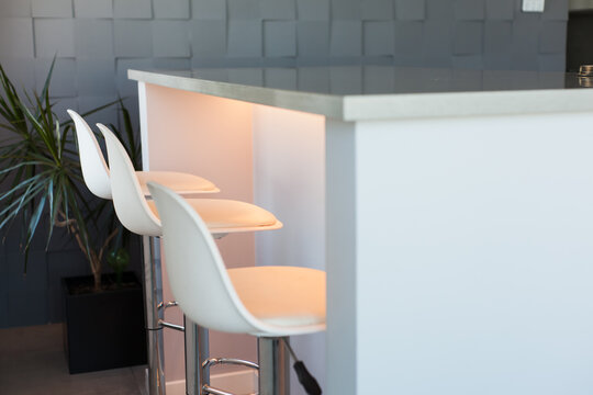 Modern minimalist kitchen interior with smooth cabinetry, soft lighting, stone surfaces and sleek fittings creating elegant contemporary design