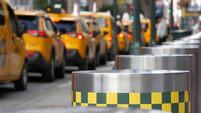 Manhattan Midtown street New York City, United States. Defocused row of yellow taxi cars. Many taxi cabs in line on 8th avenue near Penn Station. Taxi queue, urban road traffic, passenger transport.