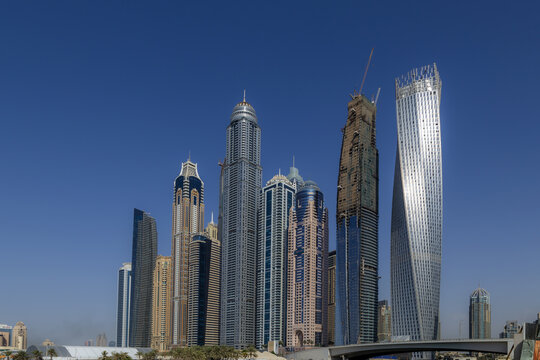 View of the modern skyscrapers of Dubai Marina, including the iconic Cayan Tower, under a clear blue sky in Dubai, Dubai, United Arab Emirates.