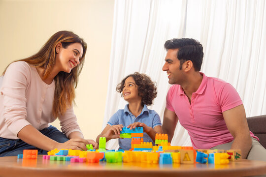 Parent and son playing together with toy blocks 