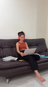 Young woman waving during video conference call on laptop at home