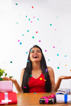 Cheerful young woman celebrating her birthday at home