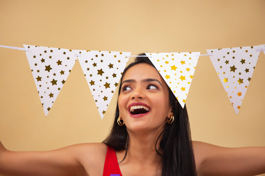 Young woman decorating home with bunting flags