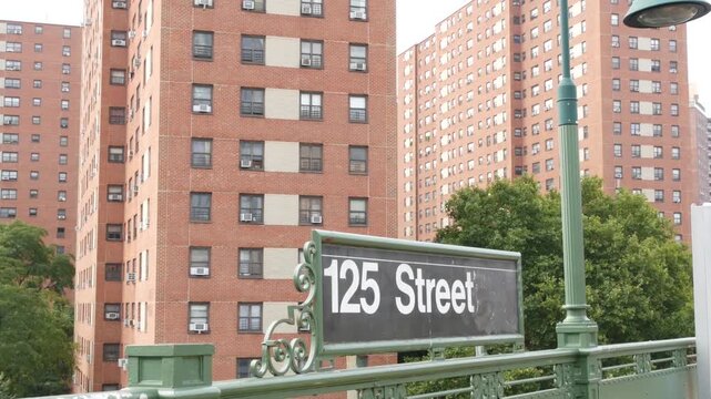 New York City Upper Manhattan subway outdoor station platform, 125 street sign, elevated metro in Harlem, United States railway. Residential district public metropolitan transport. Apartment houses.
