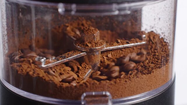 Coffee beans grinding in electric grinder process of making fresh coffee powder