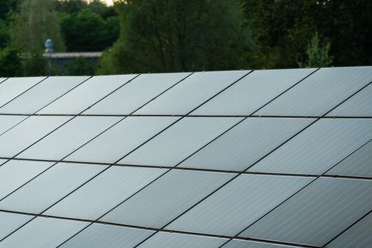 View of solar panels installed on a roof with green trees in the background in Dabrowa Gornicza, Silesian Voivodeship, Poland.