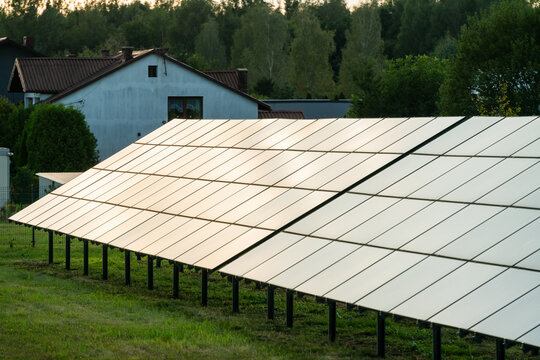 View of solar panels installed in a residential backyard with a house and trees in the background in Dabrowa Gornicza, Silesian Voivodeship, Poland.