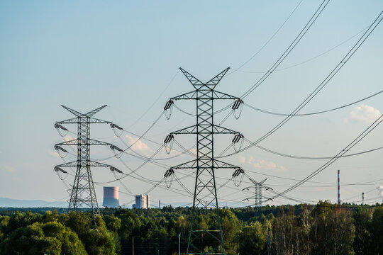 View of electricity pylons and high-voltage power lines with an industrial power plant in the background in Dabrowa Gornicza, Silesian Voivodeship, Poland.