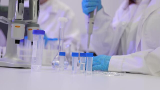 Scientist conducting research experiment in laboratory. Medical scientist in a laboratory pipetting a blue liquid into microplate wells. Scientific research and clinical development in a lab.
