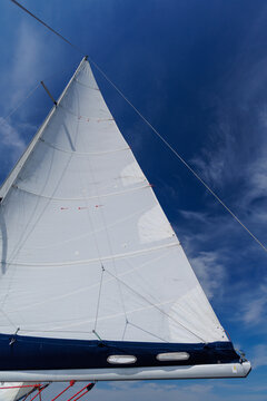 White sail against blue sky on sailing yacht