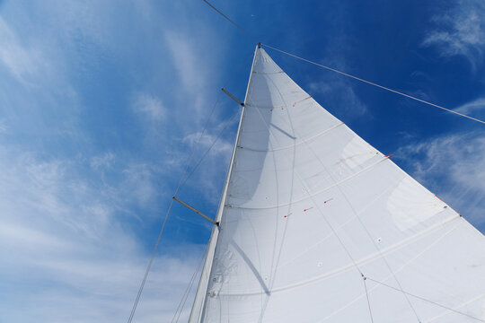 White sail against blue sky on sailing yacht