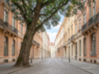 Fototapeta premium Blurred urban street lined with historic architecture, trees, balconies, and residential buildings, representing travel, city life, culture, and heritage.