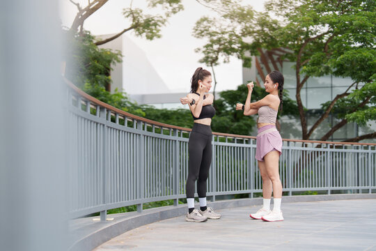 Asian women stretching arm muscles before workout for outdoor fitness routine