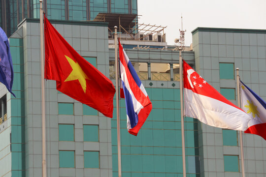 VUNG TAU, VIETNAM - FEBRUARY 5, 2026: National flags of Vietnam, Thailand, Singapore and Philippines waving on flagpoles against a modern building facade.