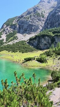 Vertical real time view across Seebensee in Tyrol with turquoise water alpine forest and dramatic mountain scenery near Zugspitze.