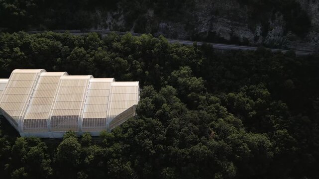 Aerial drone footage of the modern glass protective structure and visitor center at Lepenski Vir archaeological site in Iron Gate National Park, Serbia. 20.07.2026