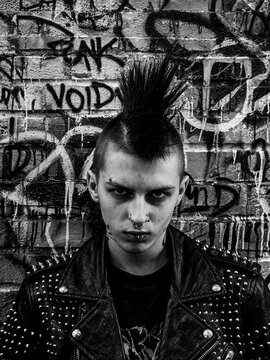 Portr&auml;t eines Punk-Rockers in Lederjacke vor Graffiti-Wand