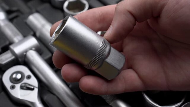 Male hand choosing and pointing at socket head in organized toolbox case close-up, auto mechanic repair concept