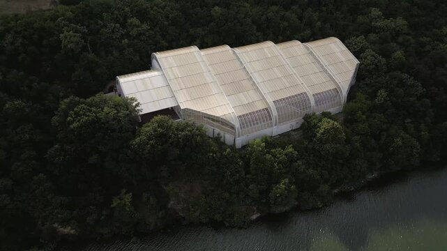 Aerial drone footage of the modern glass protective structure and visitor center at Lepenski Vir archaeological site in Iron Gate National Park, Serbia. 20.07.2026
