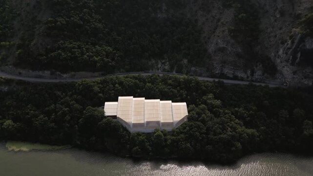 Aerial drone footage of the modern glass protective structure and visitor center at Lepenski Vir archaeological site in Iron Gate National Park, Serbia. 20.07.2026