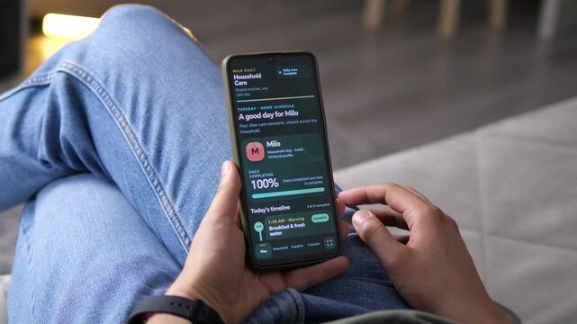 Person checks a digital pet care schedule on a smartphone, tracking feeding and daily routines for a household dog and reflecting the rise of organized mobile pet management.