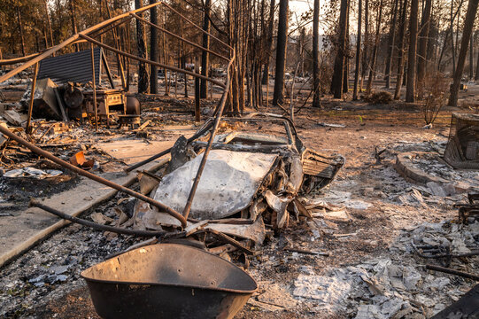 View of a destroyed car and charred forest remains in the aftermath of a wildfire in Spokane, Washington, United States.