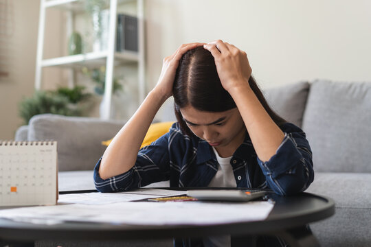 young asian woman cover her face after stressed with monthly bill expenses and credit card debt.