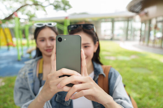 Asian female tourists taking selfie with smartphone outdoors on travel vacation